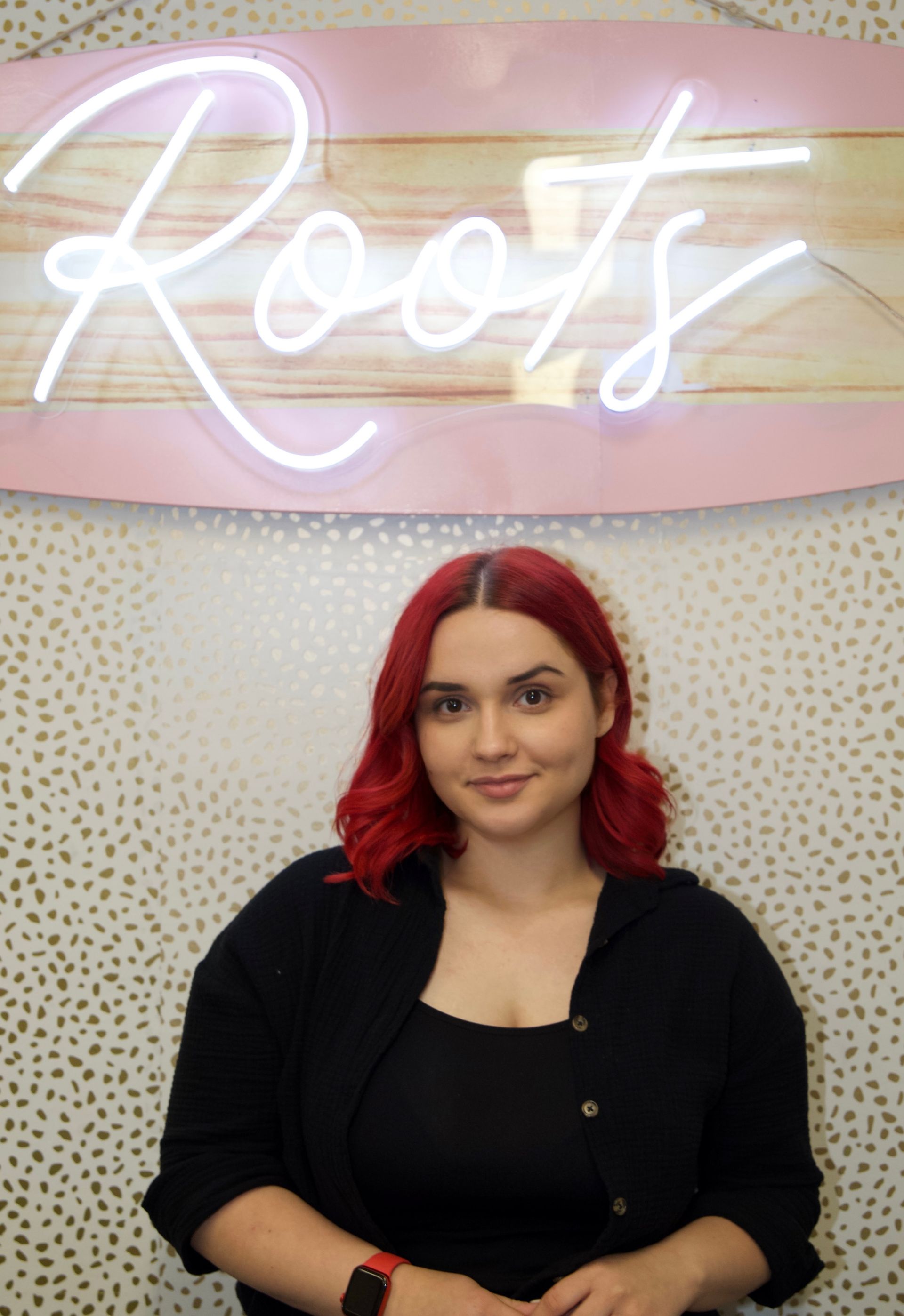 A woman with red hair is wearing a black jacket