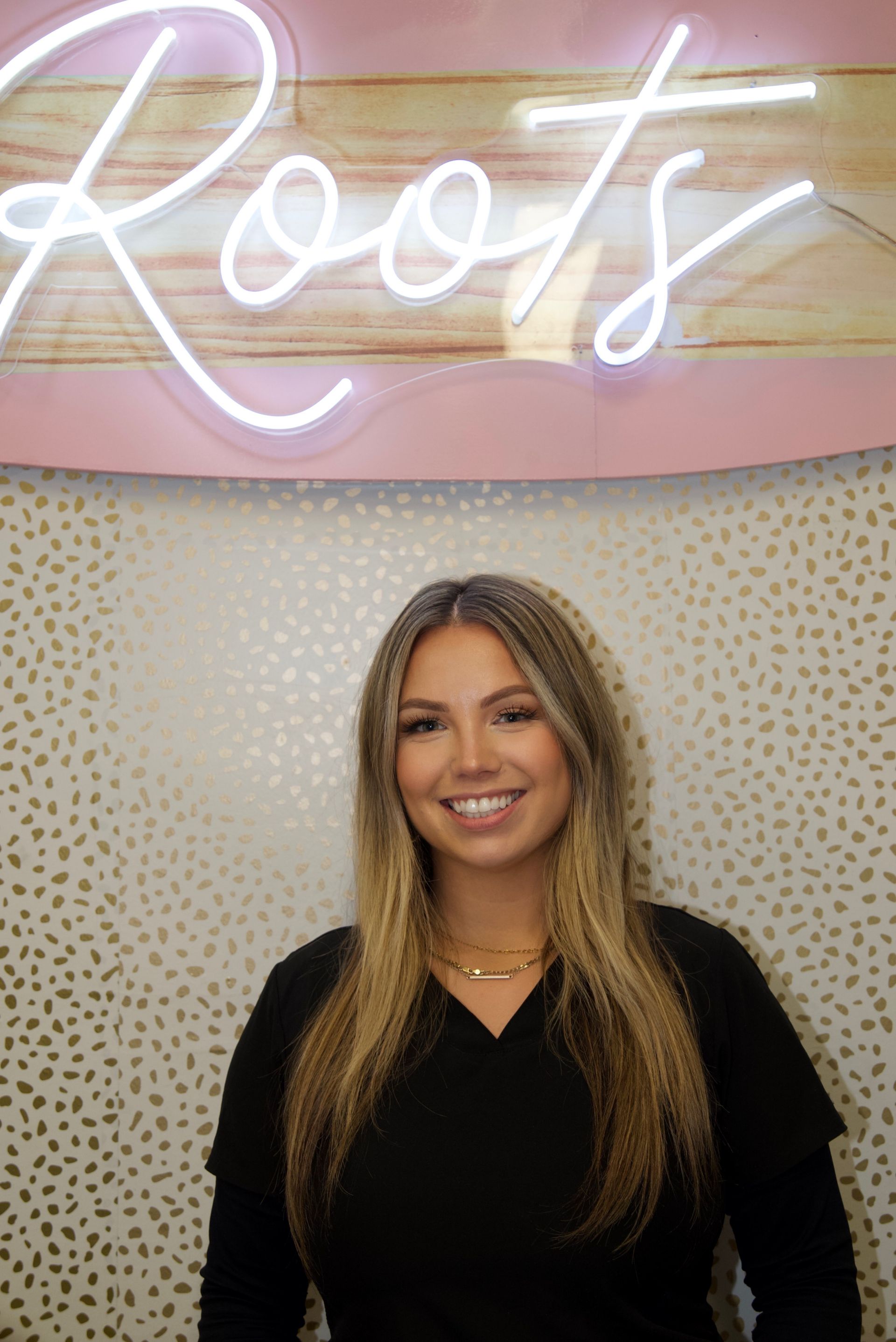 A woman wearing a black scrub top with gina written on it