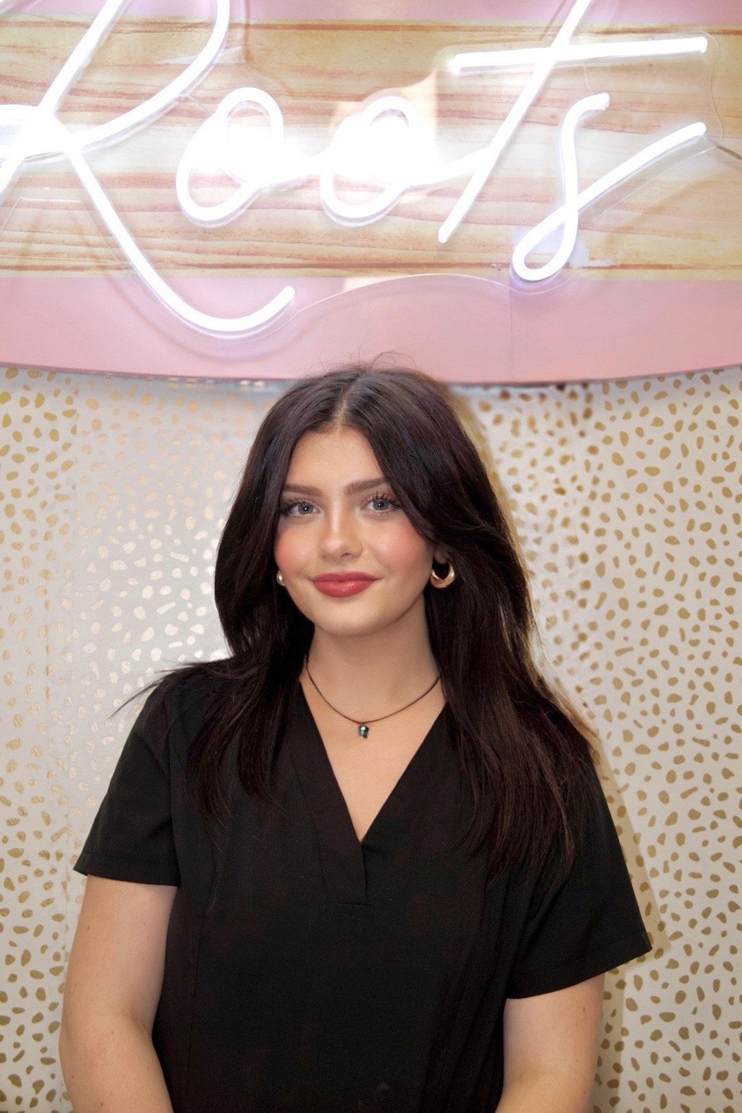 A woman wearing a black shirt that says roots made