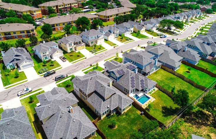 Aerial drone view above suburb rooftops