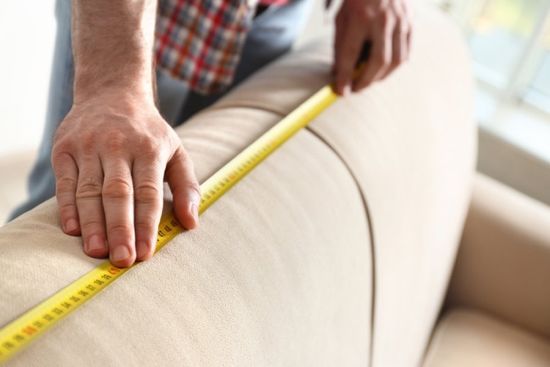 mani di artigiano misurano un divano