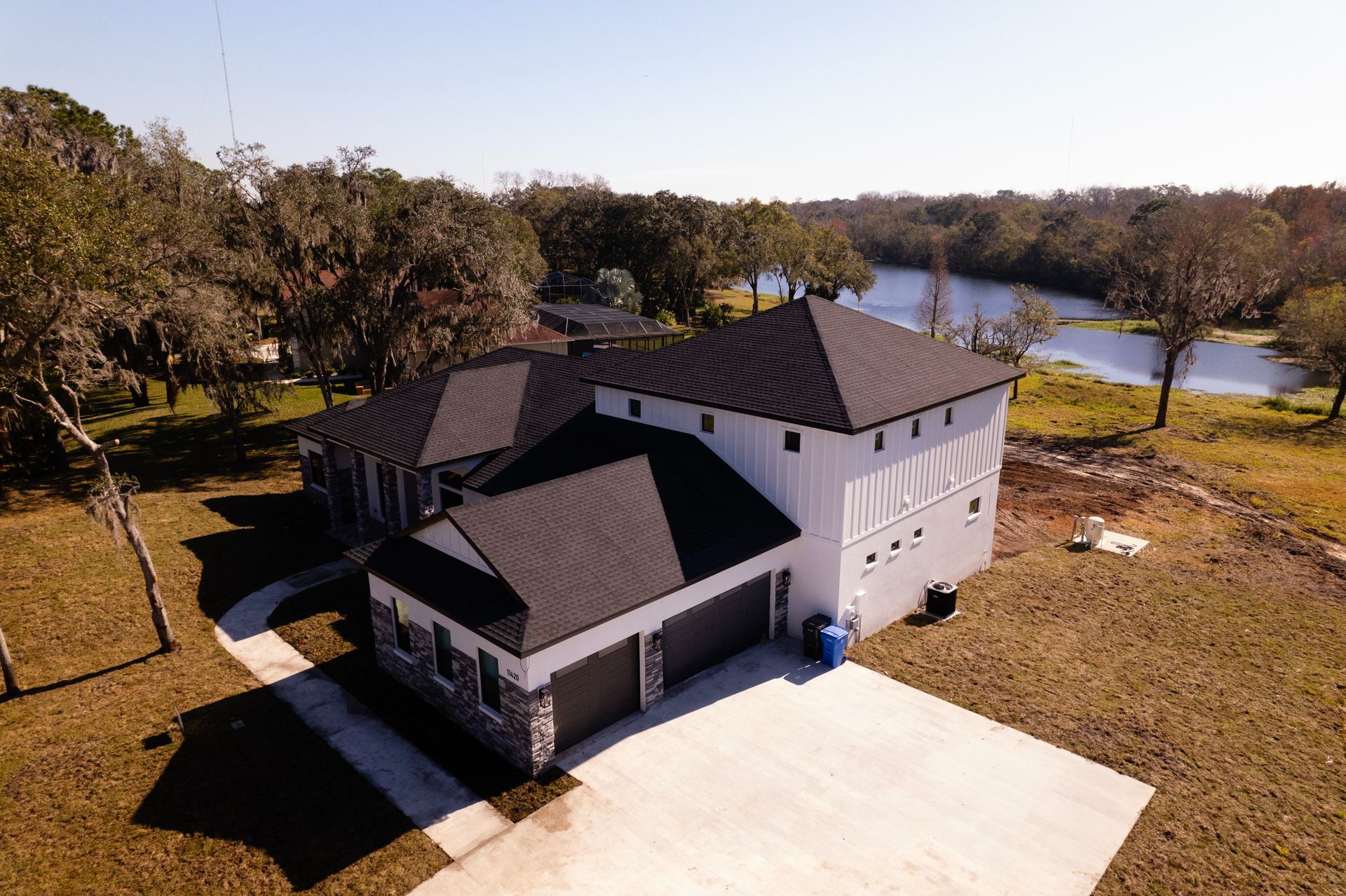 An aerial view of a house with a lake in the background.