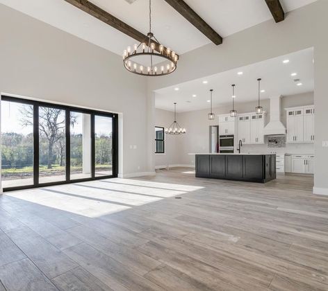An empty kitchen with a large island and lots of windows