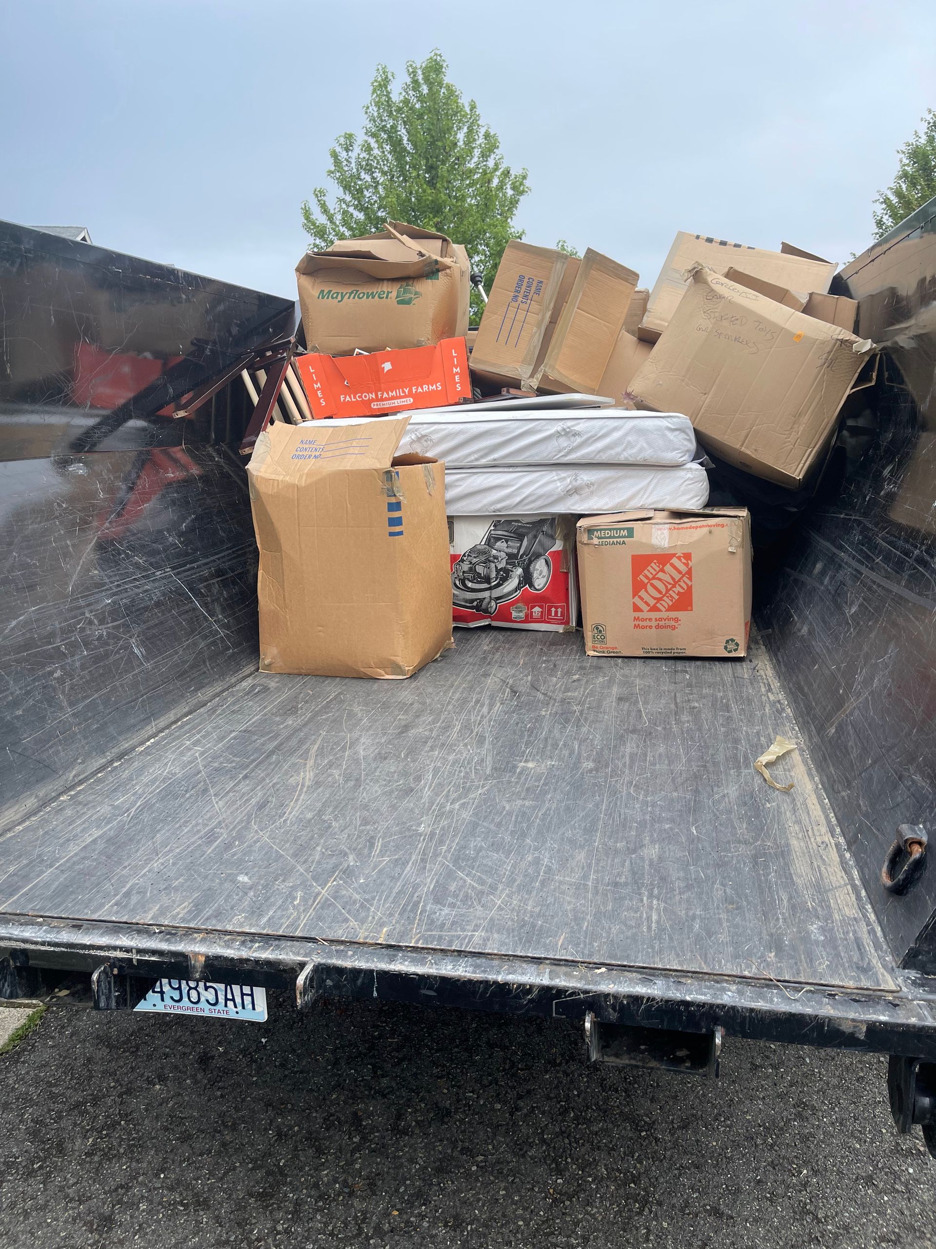 Boxes and other items piled in the bed of a black truck.