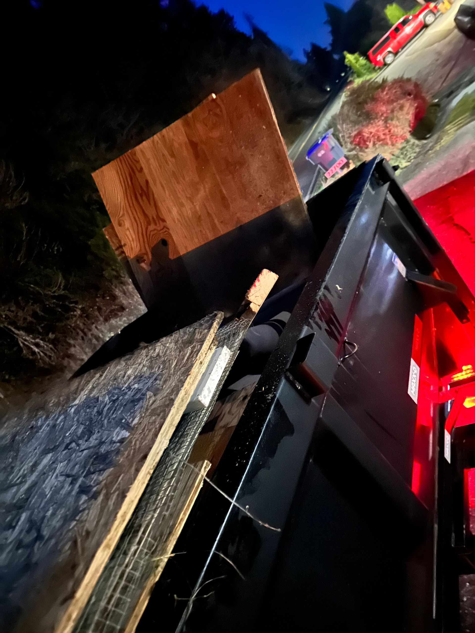 Overhead view of a wooden table atop a black container with a blurred image of cars in the background.