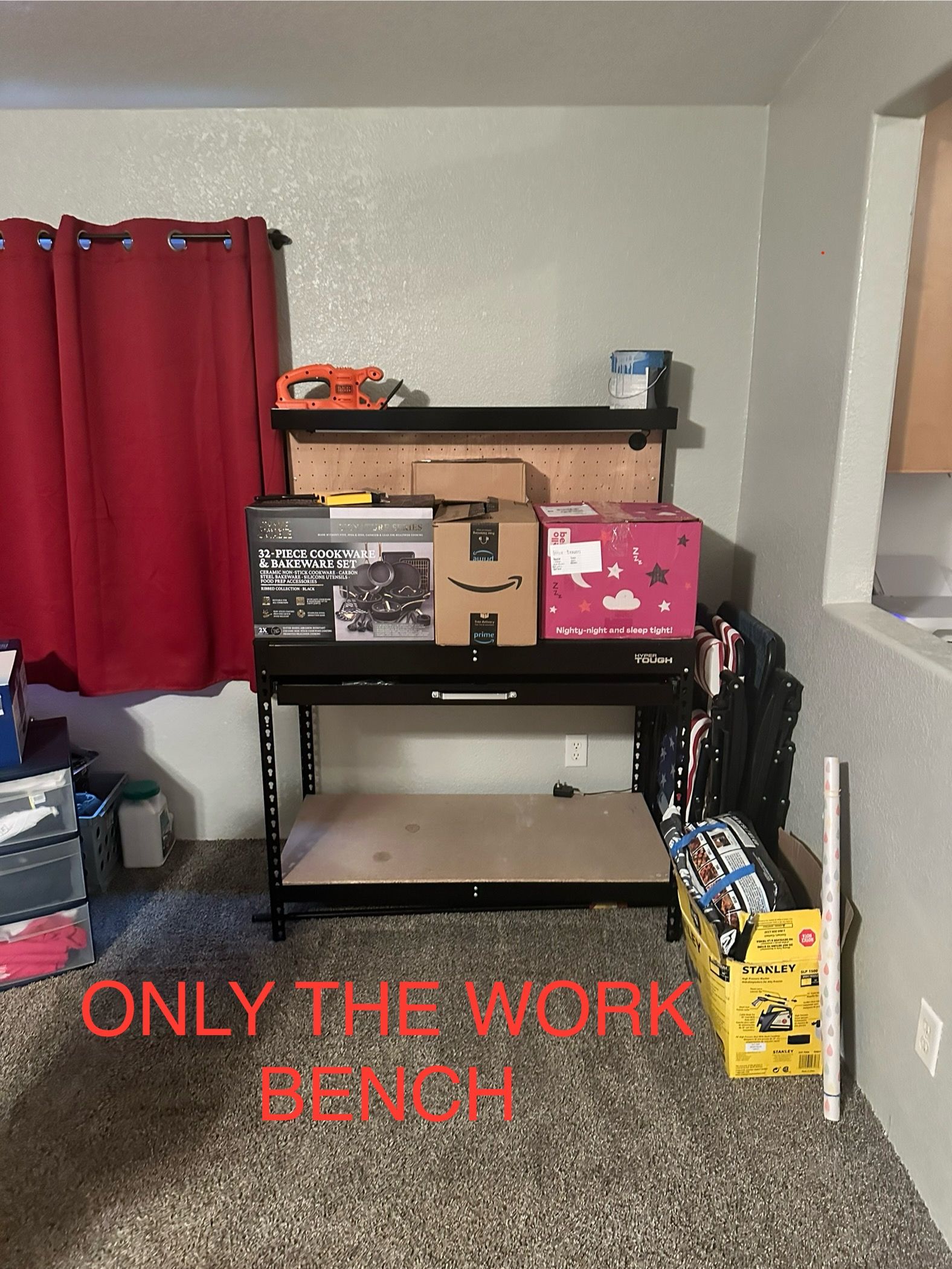 Black work bench in a room with boxes and tools on it.