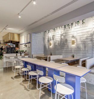 A restaurant with blue tables and white chairs