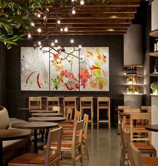 A restaurant with tables and chairs and a painting on the wall