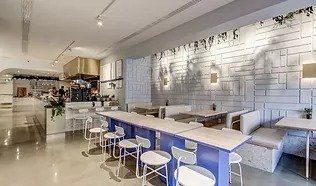 A restaurant with tables and chairs and a brick wall.