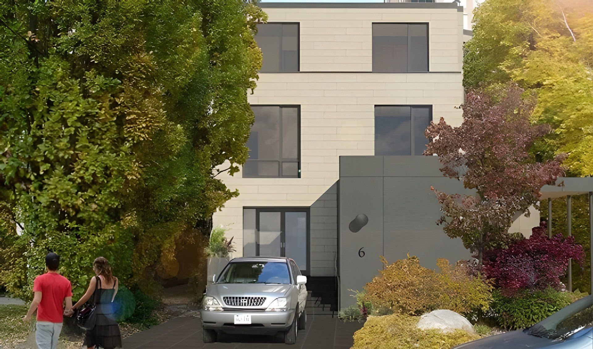 A silver car is parked in front of a house