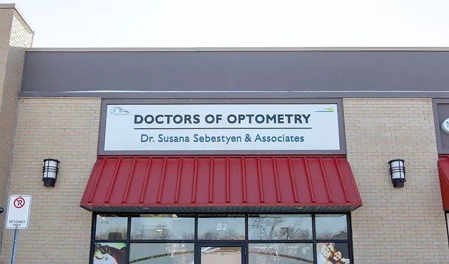 The front of a doctors of optometry store with a red awning