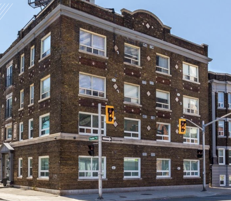 A brick building with a yellow traffic light on the corner