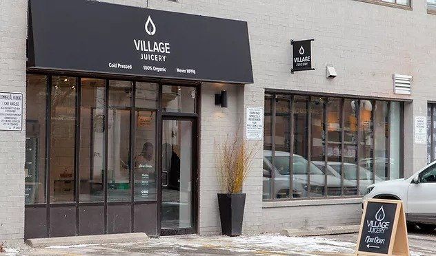 A building with a sign that says village juicery on it