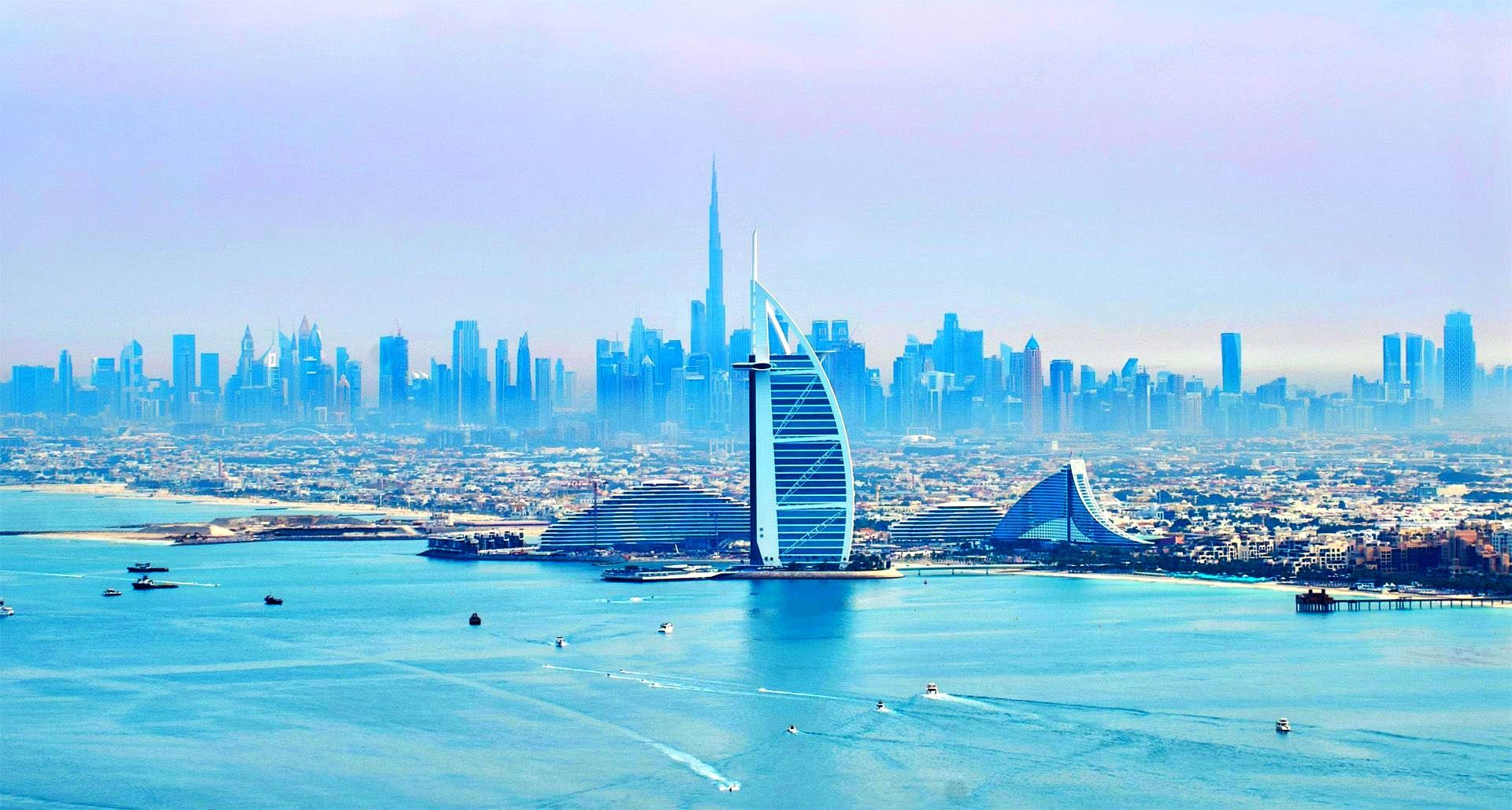 An aerial view of a city skyline with a sailboat in the foreground.