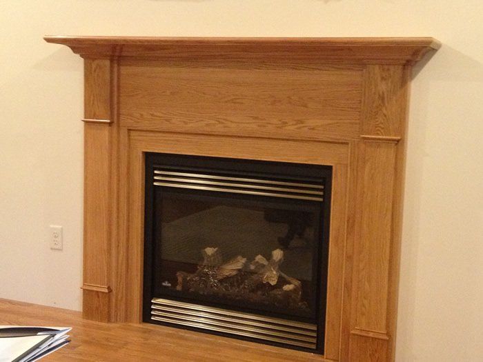 Tan wood mantel and gas fireplace installation