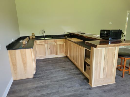 A kitchen with wooden cabinets and black counter tops