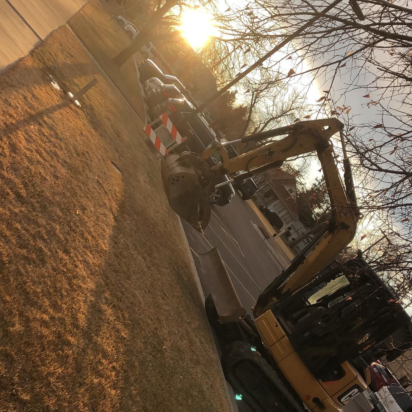 A yellow excavator is parked on the side of the road