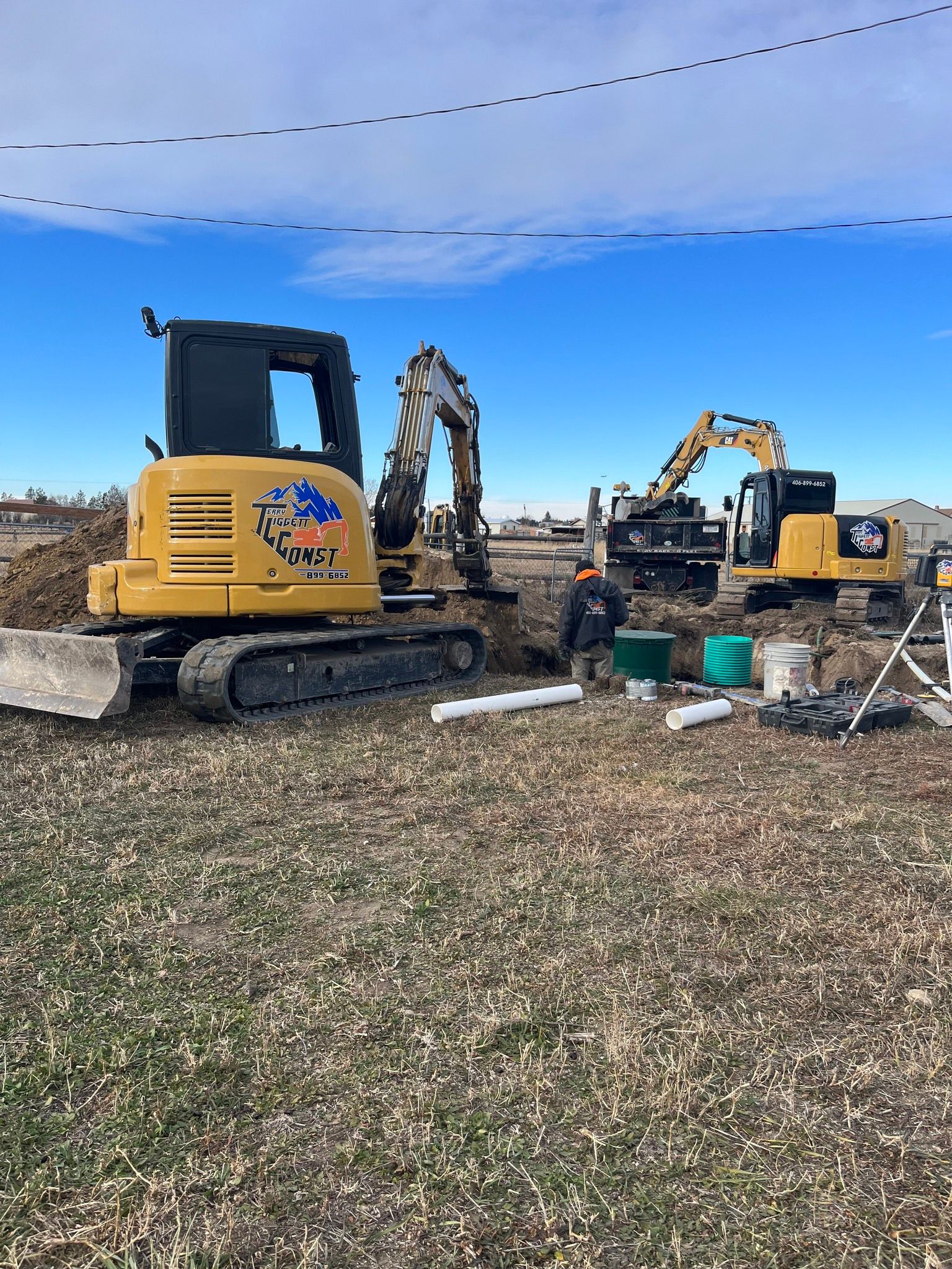 A couple of construction vehicles are parked in a field.