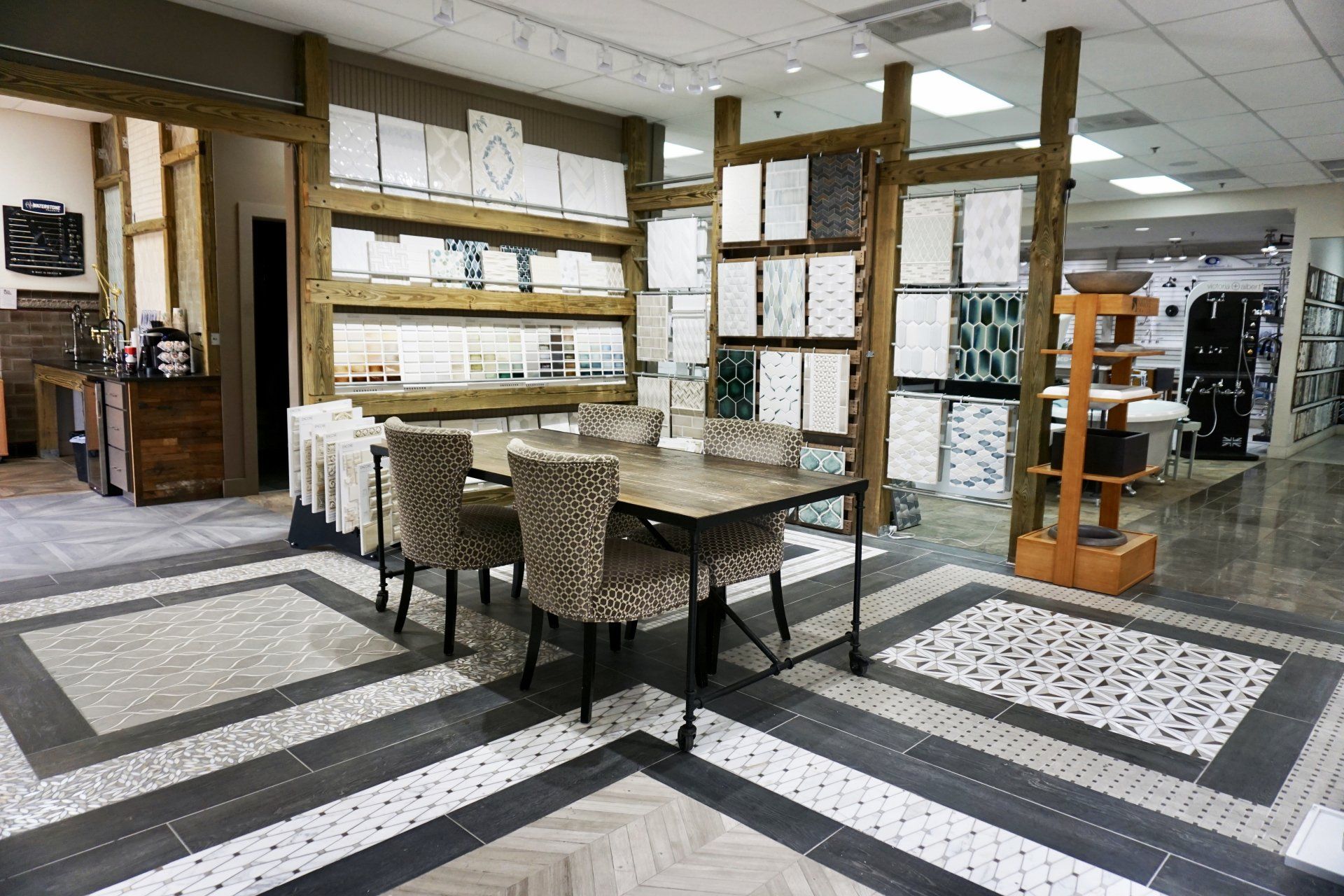 Tile showroom interior with display tables, tiles on walls, and flooring samples.