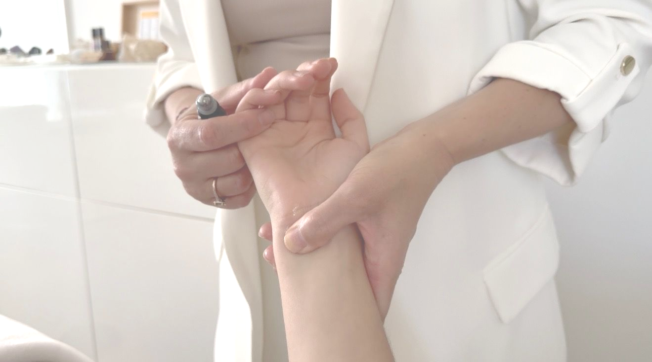 Nikki working with a client's hands on the massage table