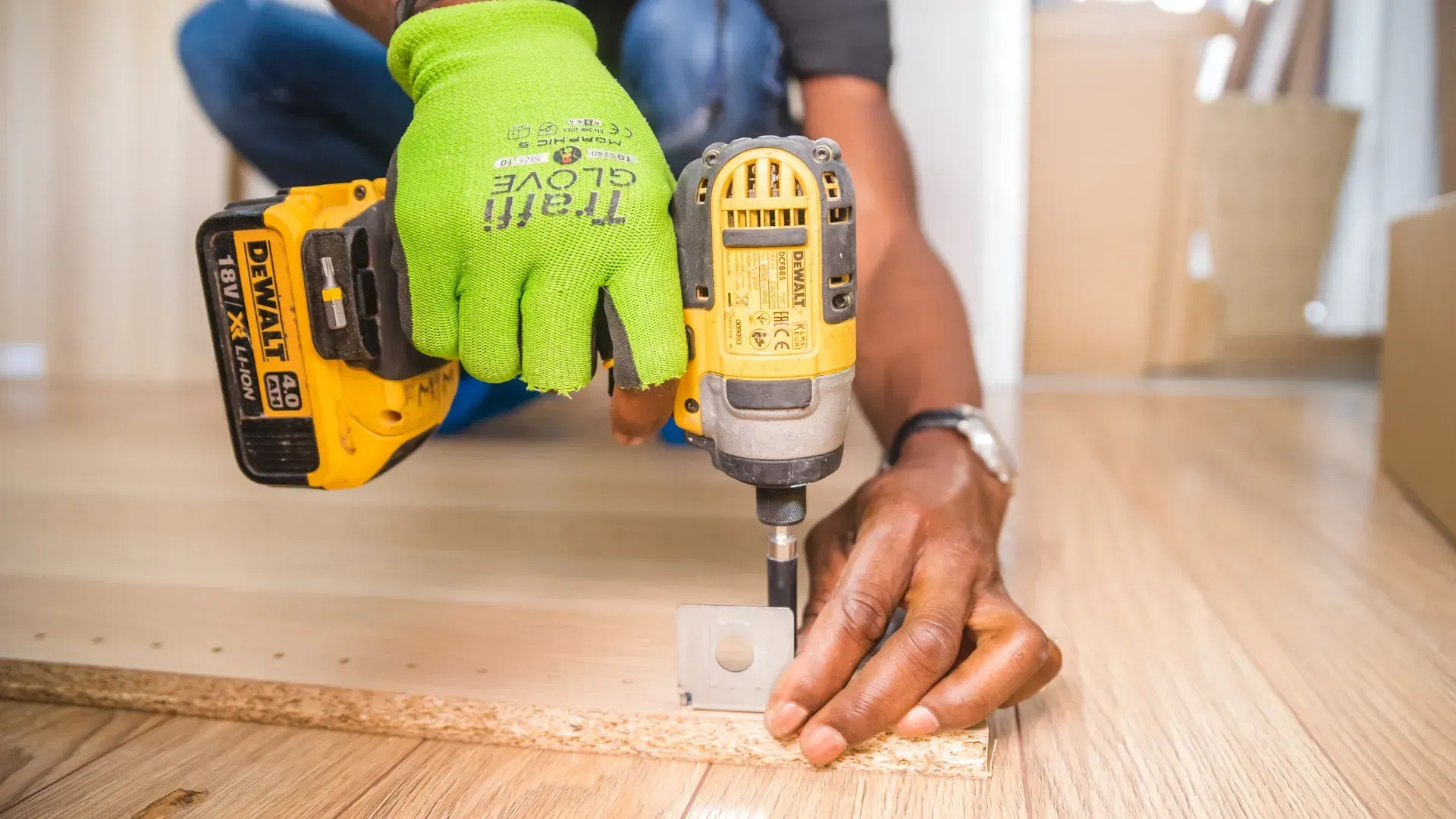 A man is using a drill to drill a hole in a piece of wood.