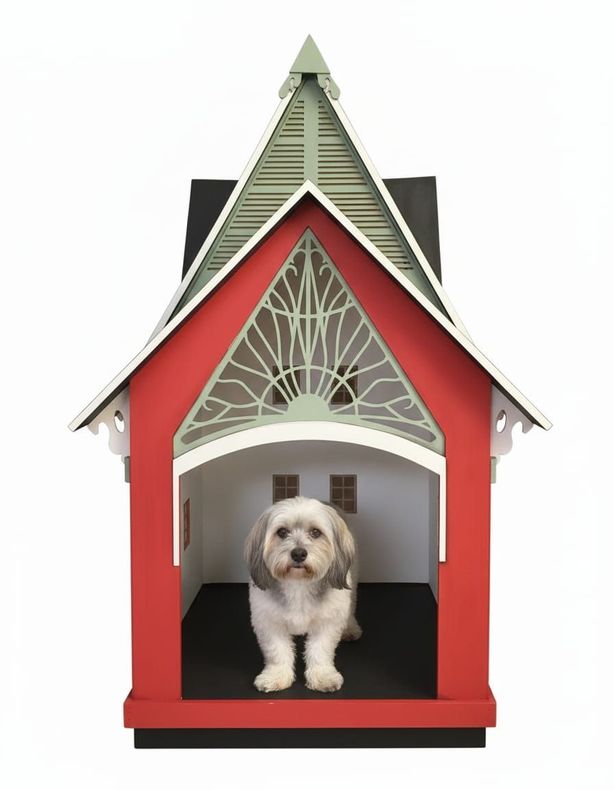 Perro dentro de una caseta roja y verde con detalles ornamentados.