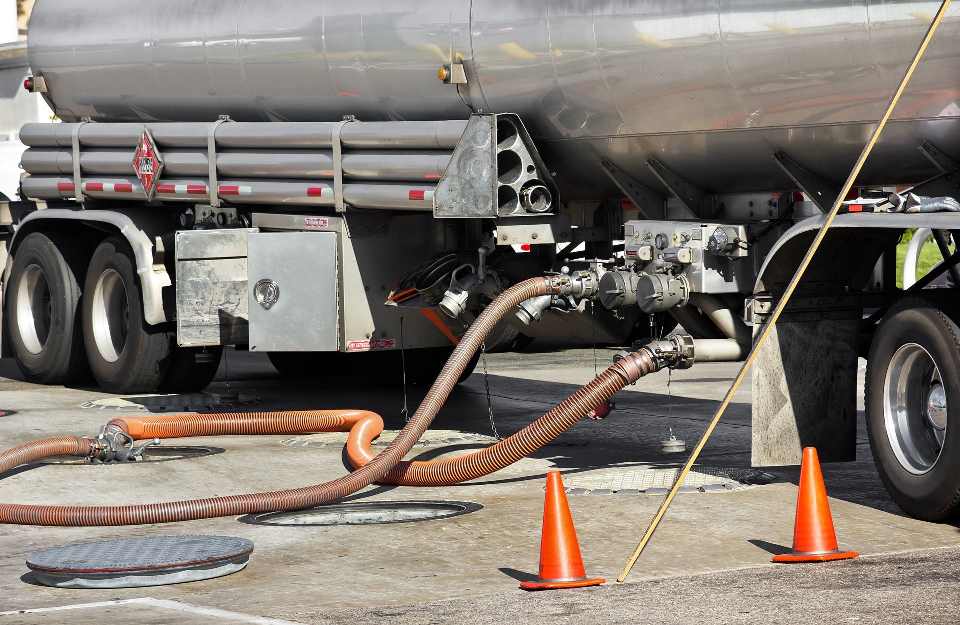 A fuel tanker, from a gasoline distributor, deposits gasoline into a storage tank at a gas station.