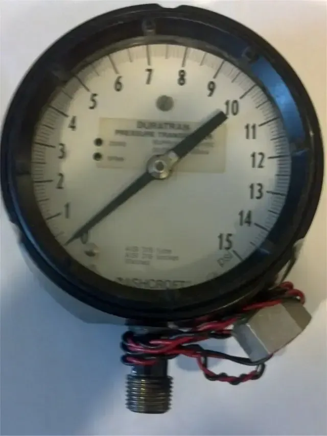 Round black analog pressure gauge with numbers and attached red-black wires