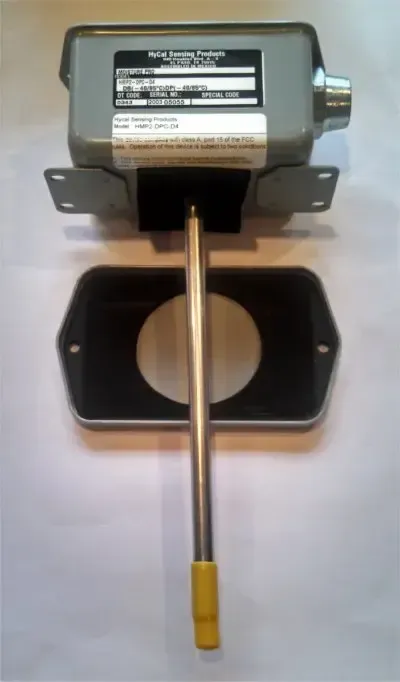 Small electric motor mounted above a black bracket with a vertical metal rod and yellow tip