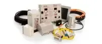Assorted electrical cords, plugs, and adapters arranged around a power supply unit on a white background