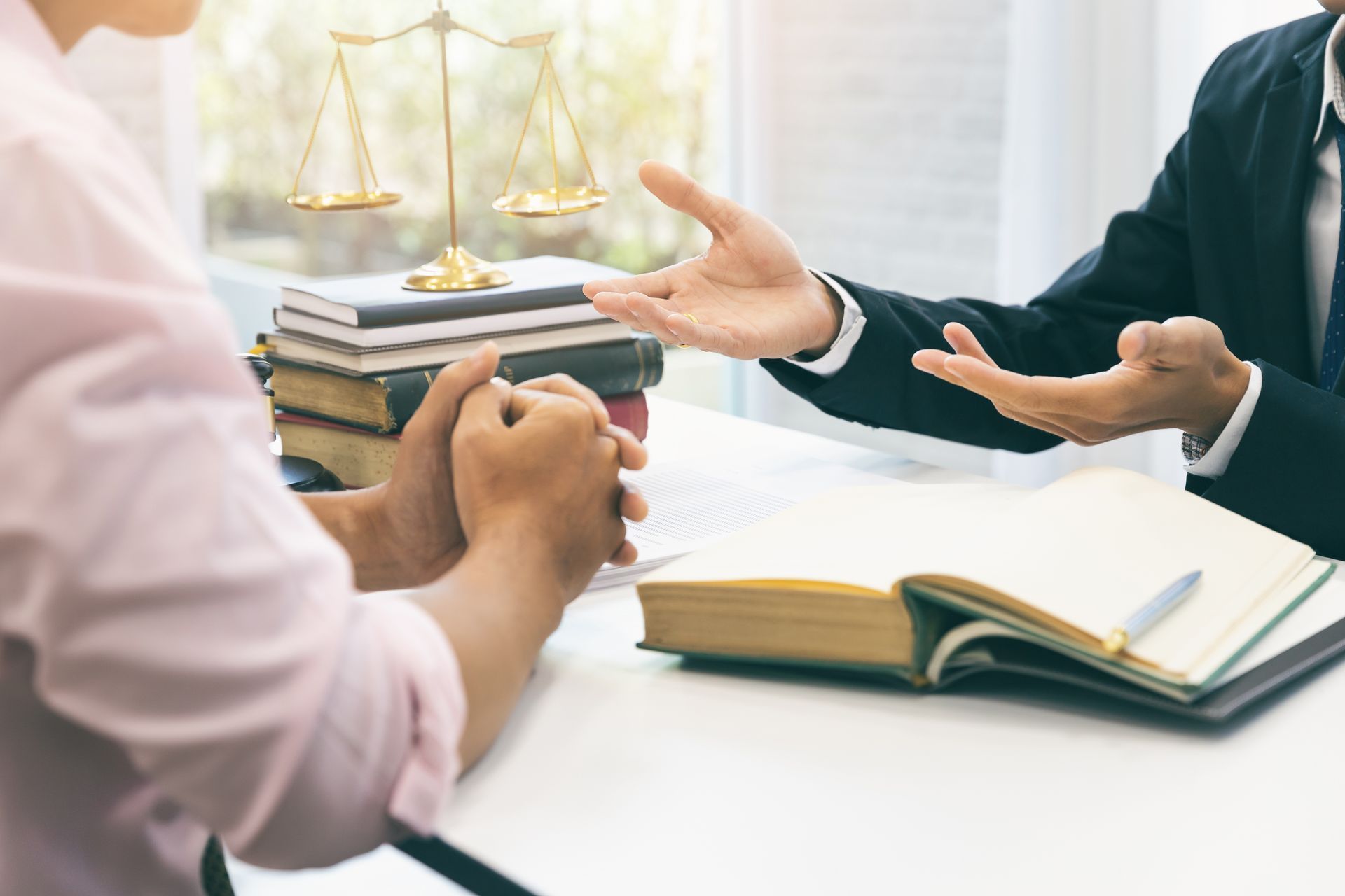 Attorney consulting with a client at a law office desk, discussing legal options. Attorney consulting with a client at a law office desk, discussing legal options.