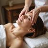Woman receiving a facial treatment with a mask on, eyes closed, lying on a white towel.