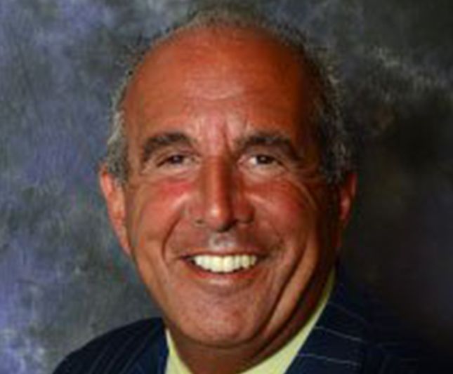 a man in a suit and tie is smiling for the camera