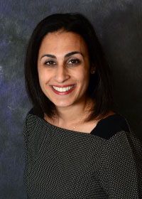 a woman is smiling for the camera in front of a black background .