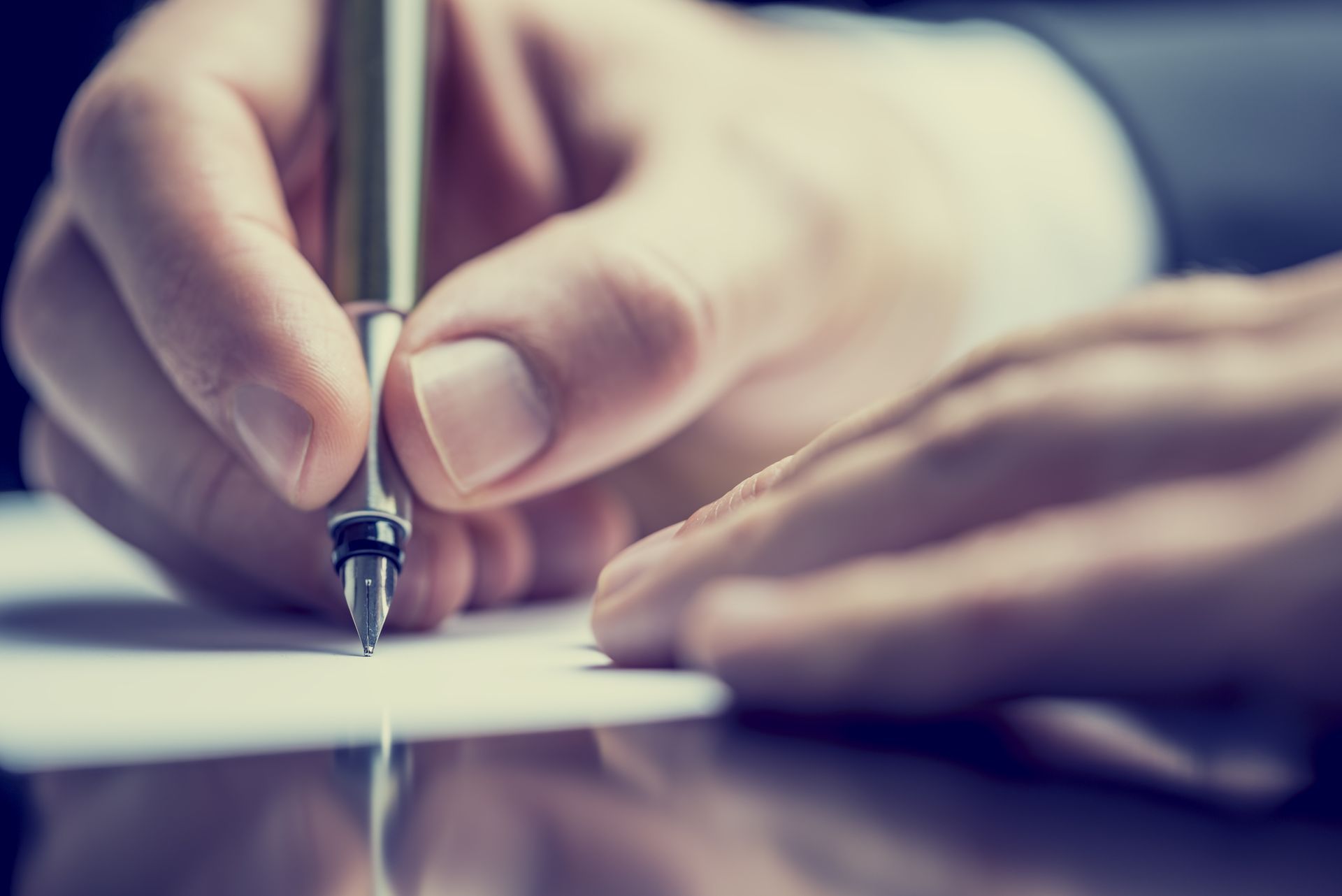 a man and a woman are sitting at a table signing a document .