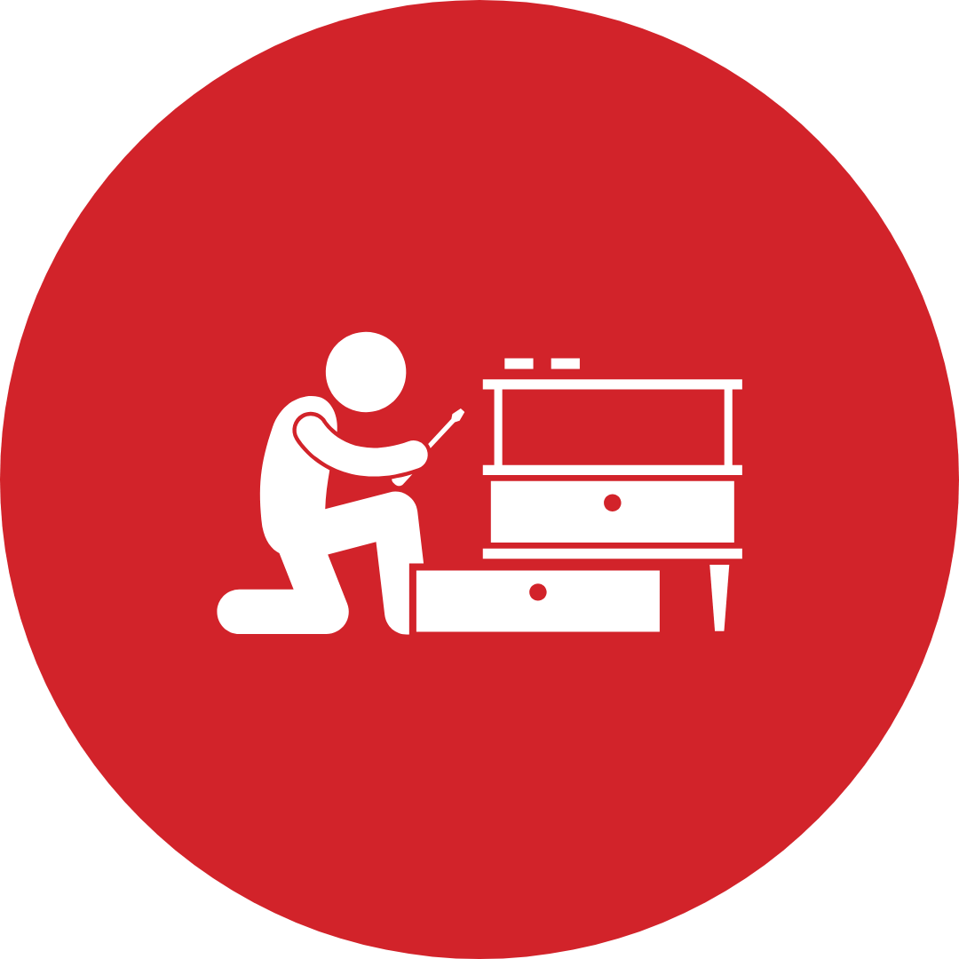 A man is kneeling down and working on a table.