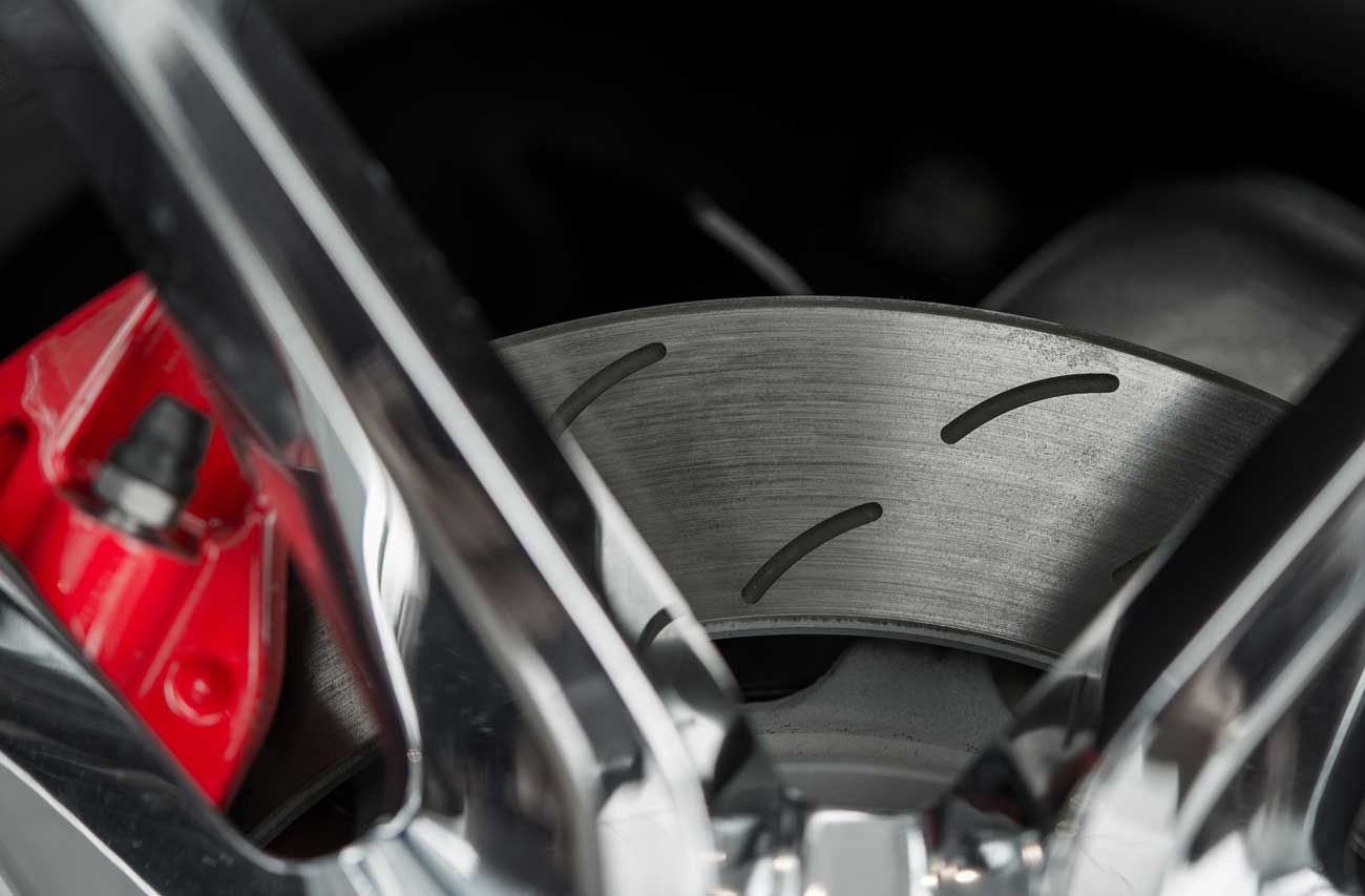 Close-up of a brake pad pressed against a new brake rotor