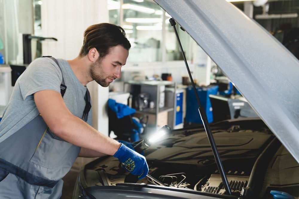 A Skilled Mechanic Is Working On A Car In A Garage With The Hood Open — Nielson Diesel Mechanics in Swan Hill, VIC