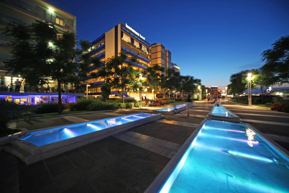Un hotel di Riccione con una fontana di fronte di notte