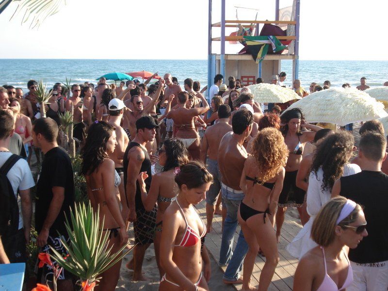 Una folla di persone balla su una spiaggia
