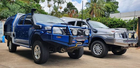 Two Modified Off-road Trucks Parked Side by Side — Edmonton Tyre and Mechanical Services in Edmonton, QLD