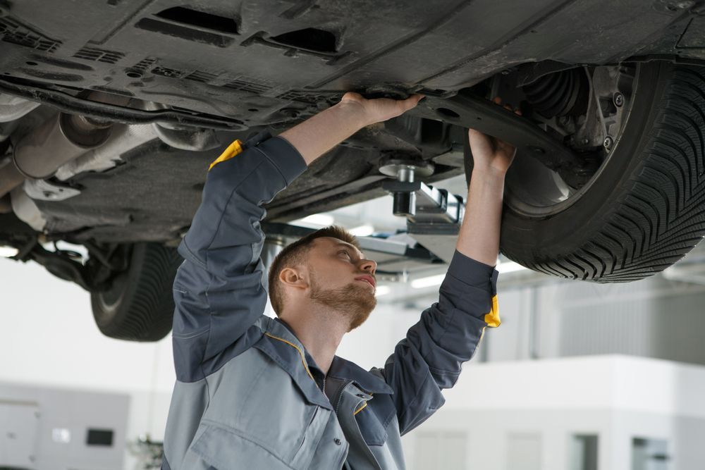 Mechanic Working on the Underside of a Car in a Garage — Edmonton Tyre and Mechanical Services in Edmonton, QLD