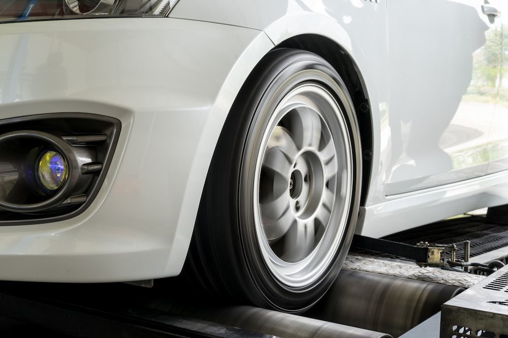 White Car Tyre on a Dynamometer; the Wheel is Spinning — Edmonton Tyre and Mechanical Services in Edmonton, QLD