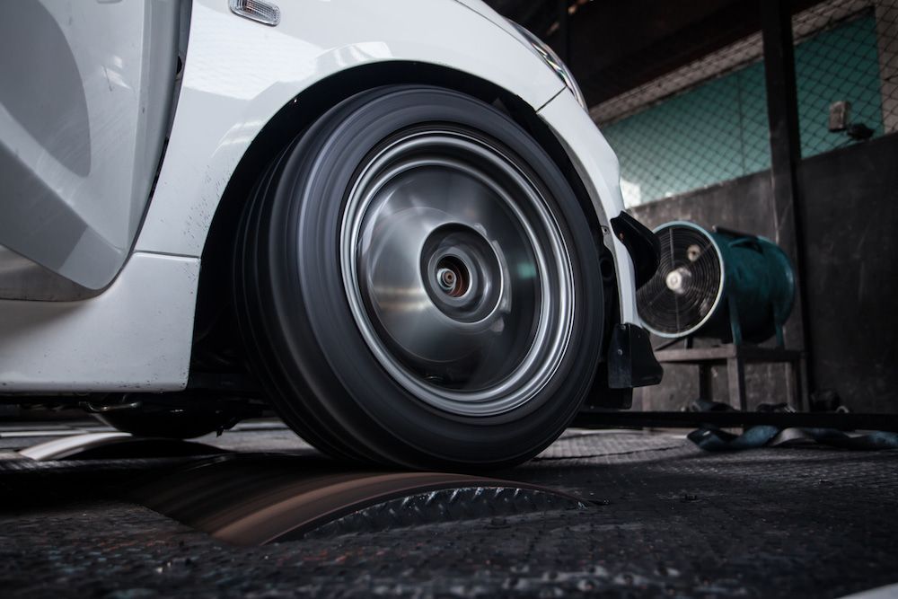 White Car Wheel Spinning on a Dyno — Edmonton Tyre and Mechanical Services in Edmonton, QLD