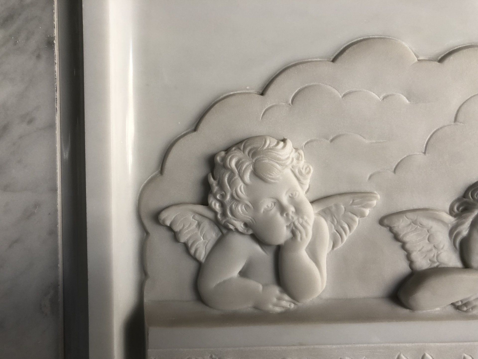 cherubini scolpiti su lastra di marmo