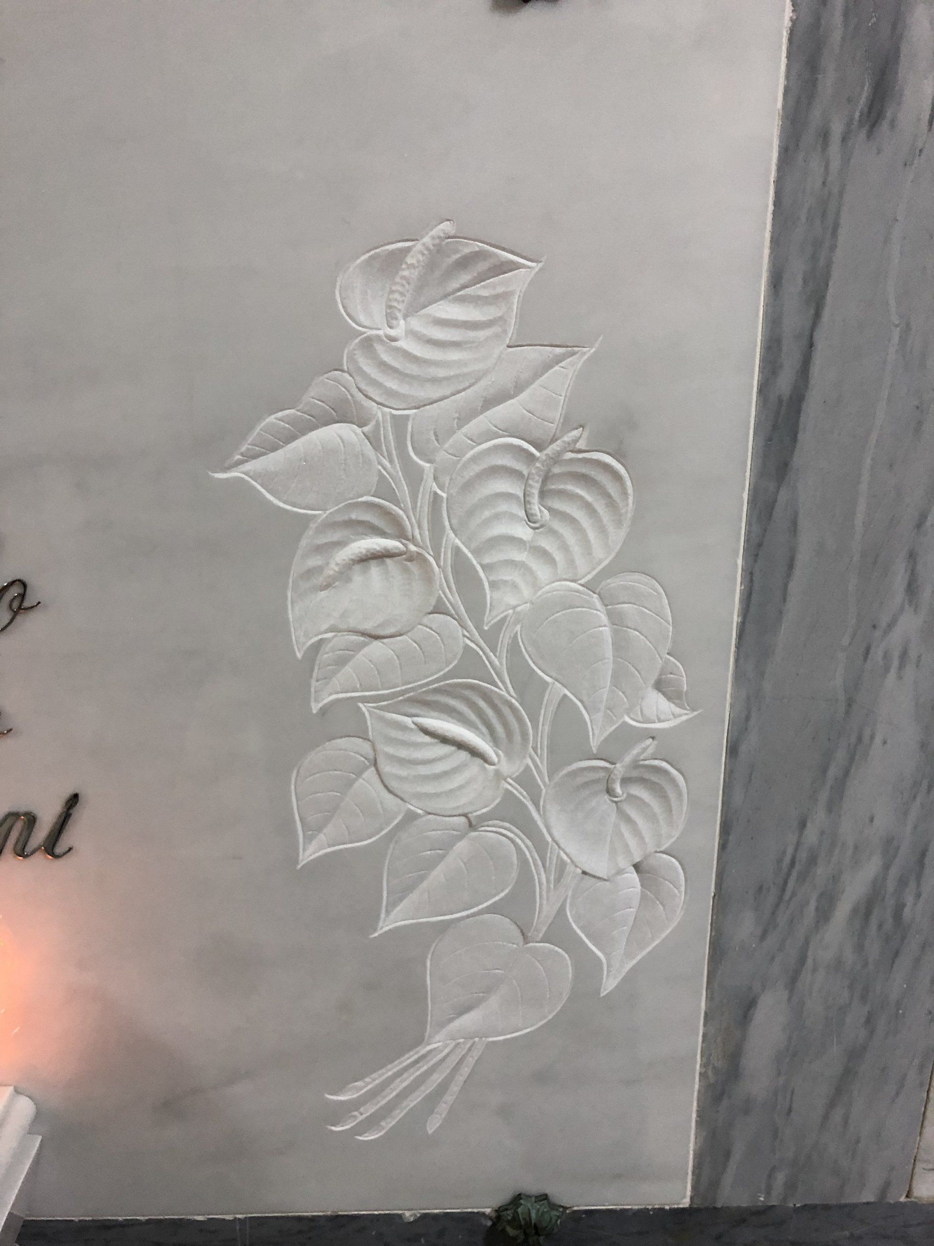 fiori in basso rilievo su lapide