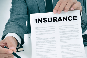A man is holding a piece of paper with the word insurance on it.