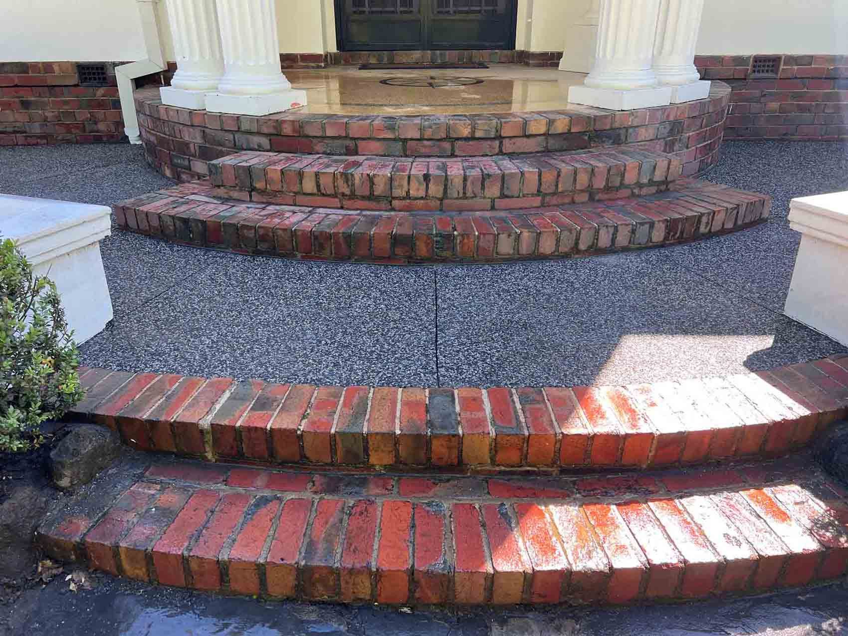 A set of brick steps leading up to a porch of a house
