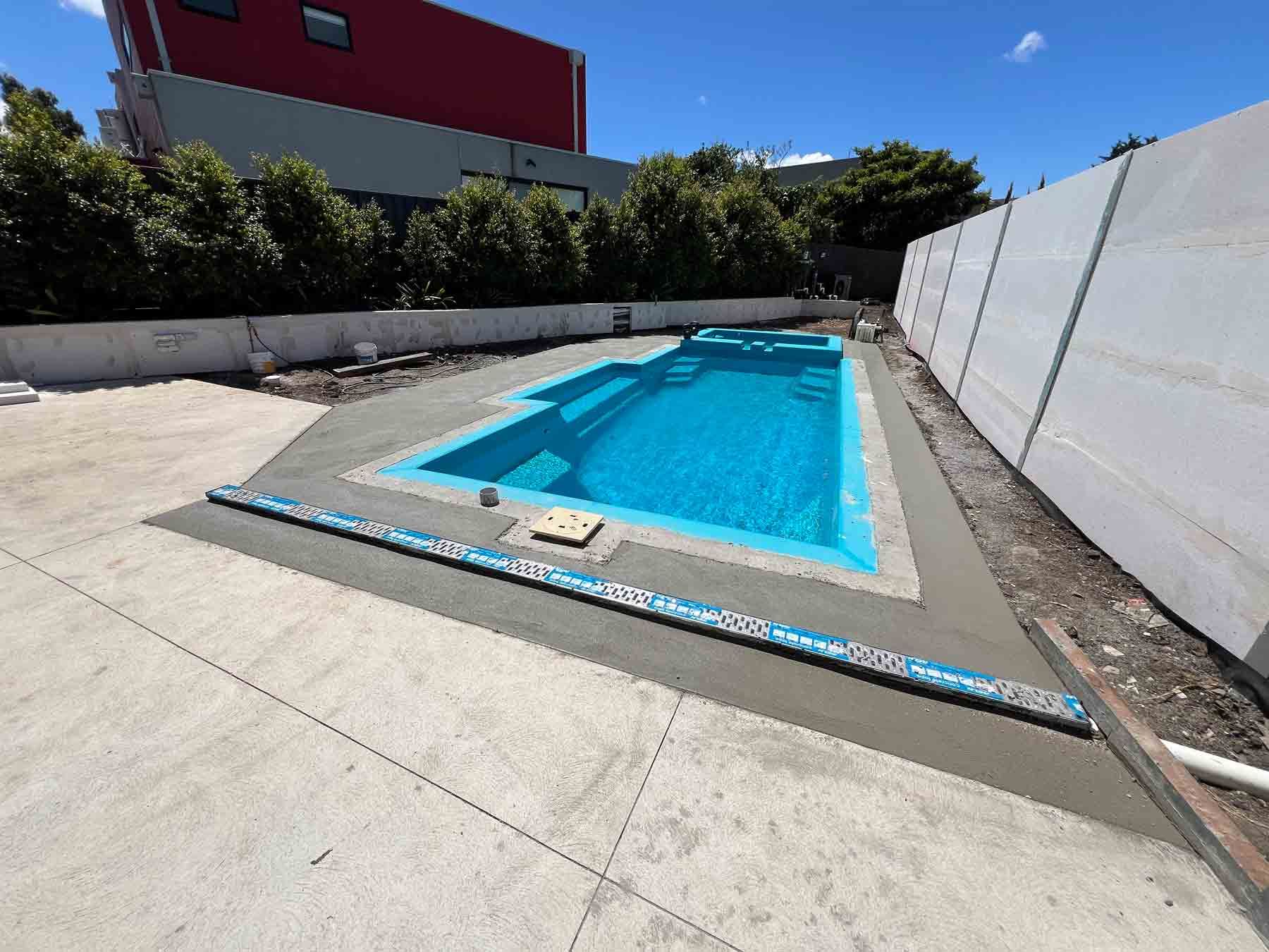 A large swimming pool is being built in a backyard