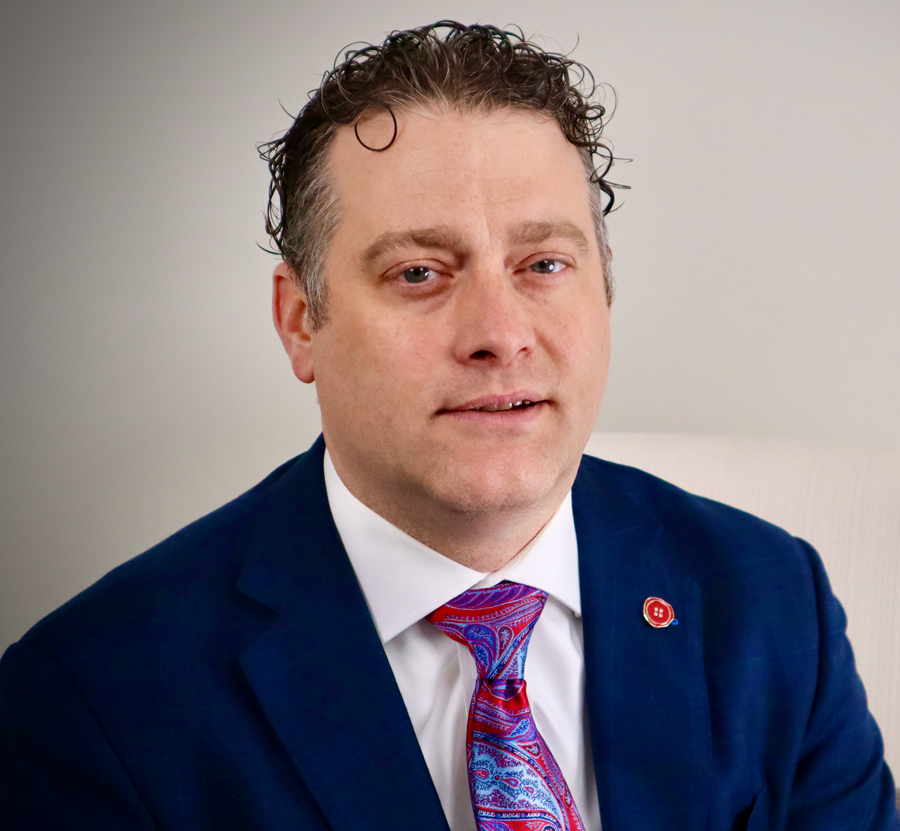 A man in a suit and tie is sitting in a chair.
